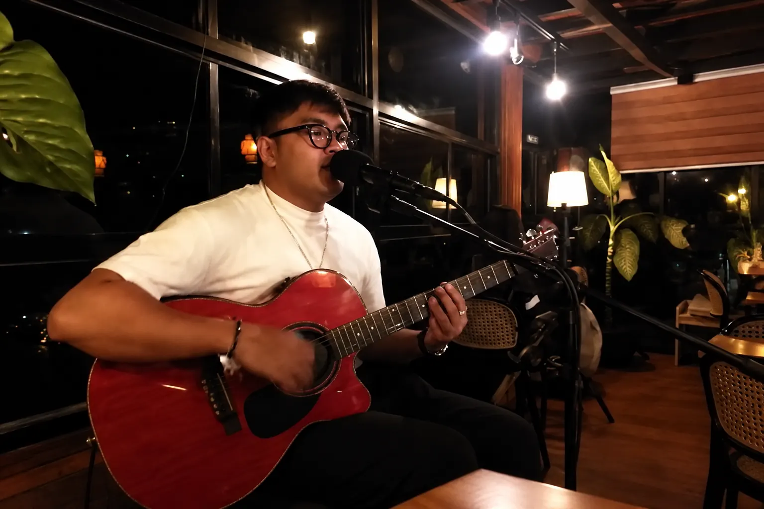 A singer with an acoustic guitar performing live at Jakarta