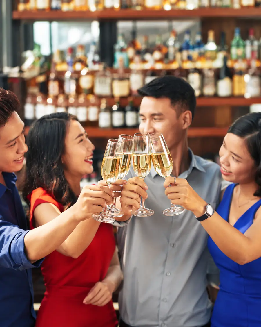 Friends raising glasses in a toast at the bar